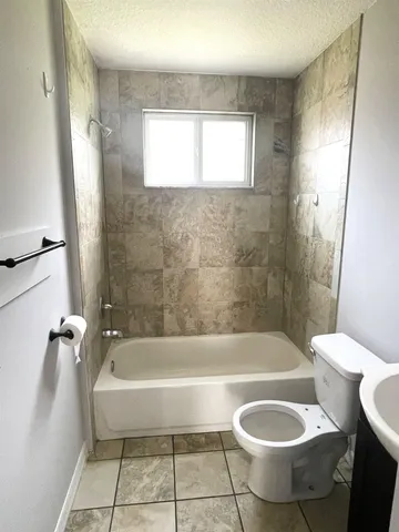 a bathroom with a sink a toilet and bathtub