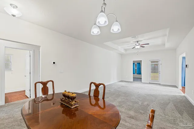 a kitchen with kitchen island stainless steel appliances granite countertop a sink a stove and a dining table with wooden floor