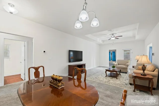 a living room with furniture chandelier and a flat screen tv