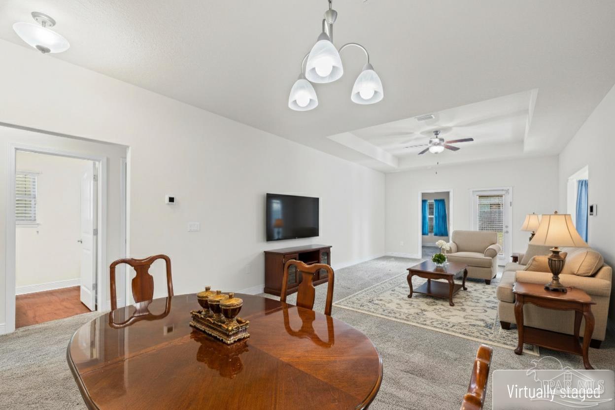 4442 Fiske Street Pace, FL 32571 - Photo 13 of 44 a living room with furniture chandelier and a flat screen tv