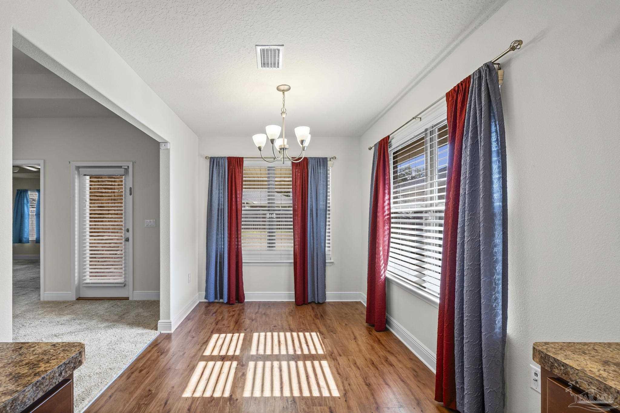 4442 Fiske Street Pace, FL 32571 - Photo 17 of 44 an entryway with a chandelier and wooden floor