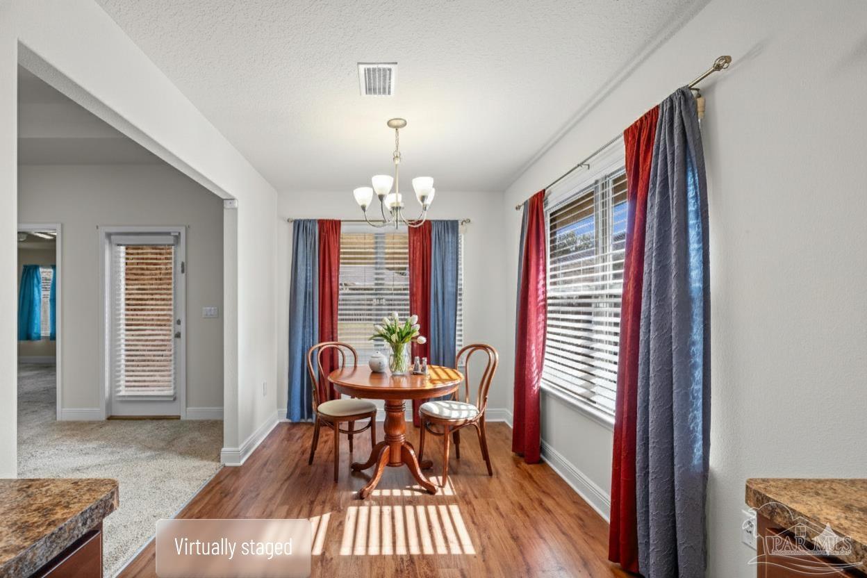 4442 Fiske Street Pace, FL 32571 - Photo 18 of 44 a view of a dining room with furniture and wooden floor