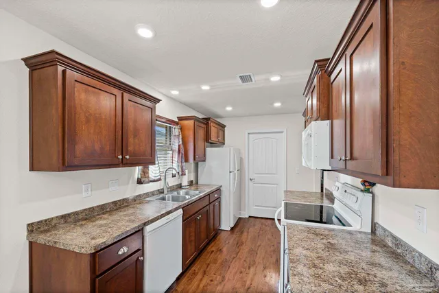 a kitchen with stainless steel appliances granite countertop a sink stove and cabinets