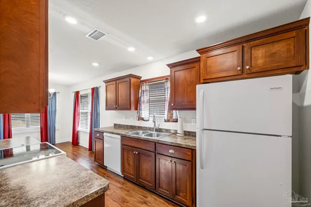 a kitchen with stainless steel appliances granite countertop a refrigerator a stove a sink and a microwave