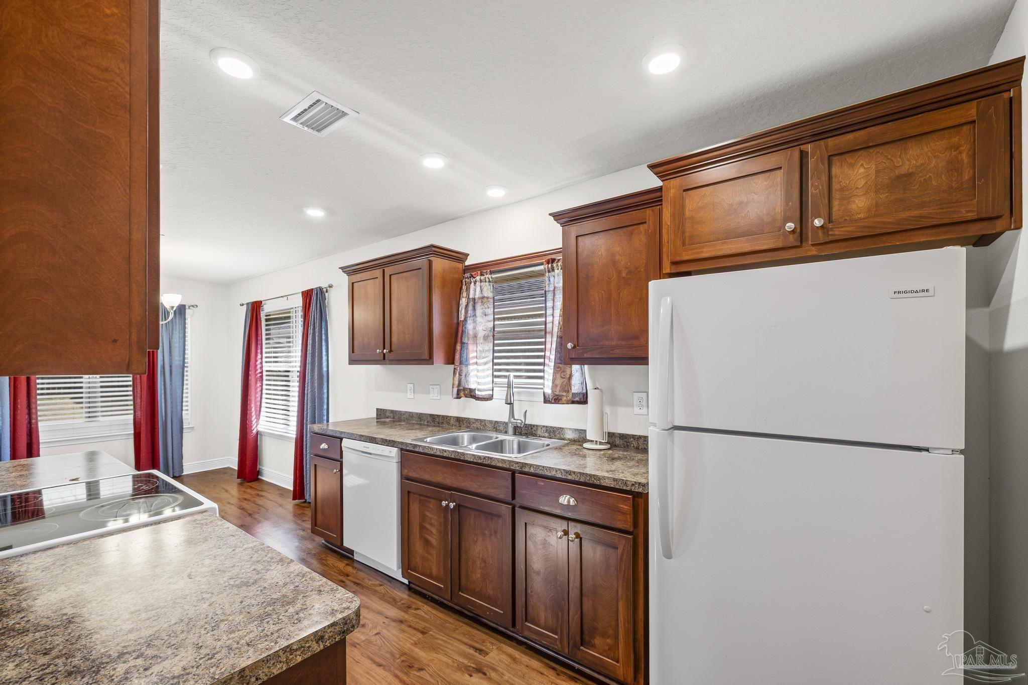 4442 Fiske Street Pace, FL 32571 - Photo 23 of 44 a kitchen with stainless steel appliances granite countertop a refrigerator a stove a sink and a microwave