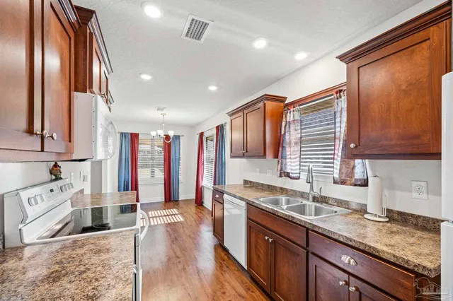 a large kitchen with stainless steel appliances granite countertop a sink and dishwasher with wooden floor