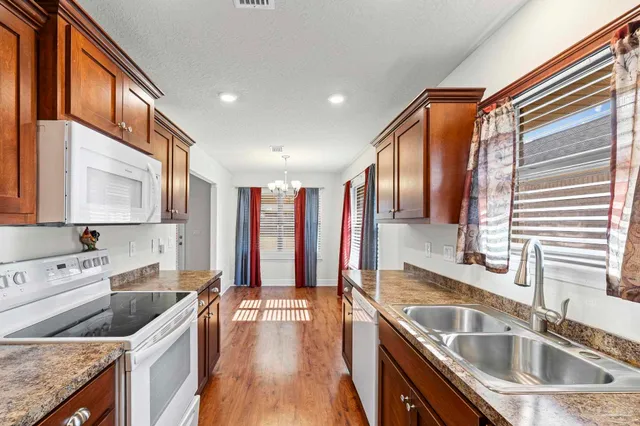 a kitchen with a sink stove top oven and refrigerator