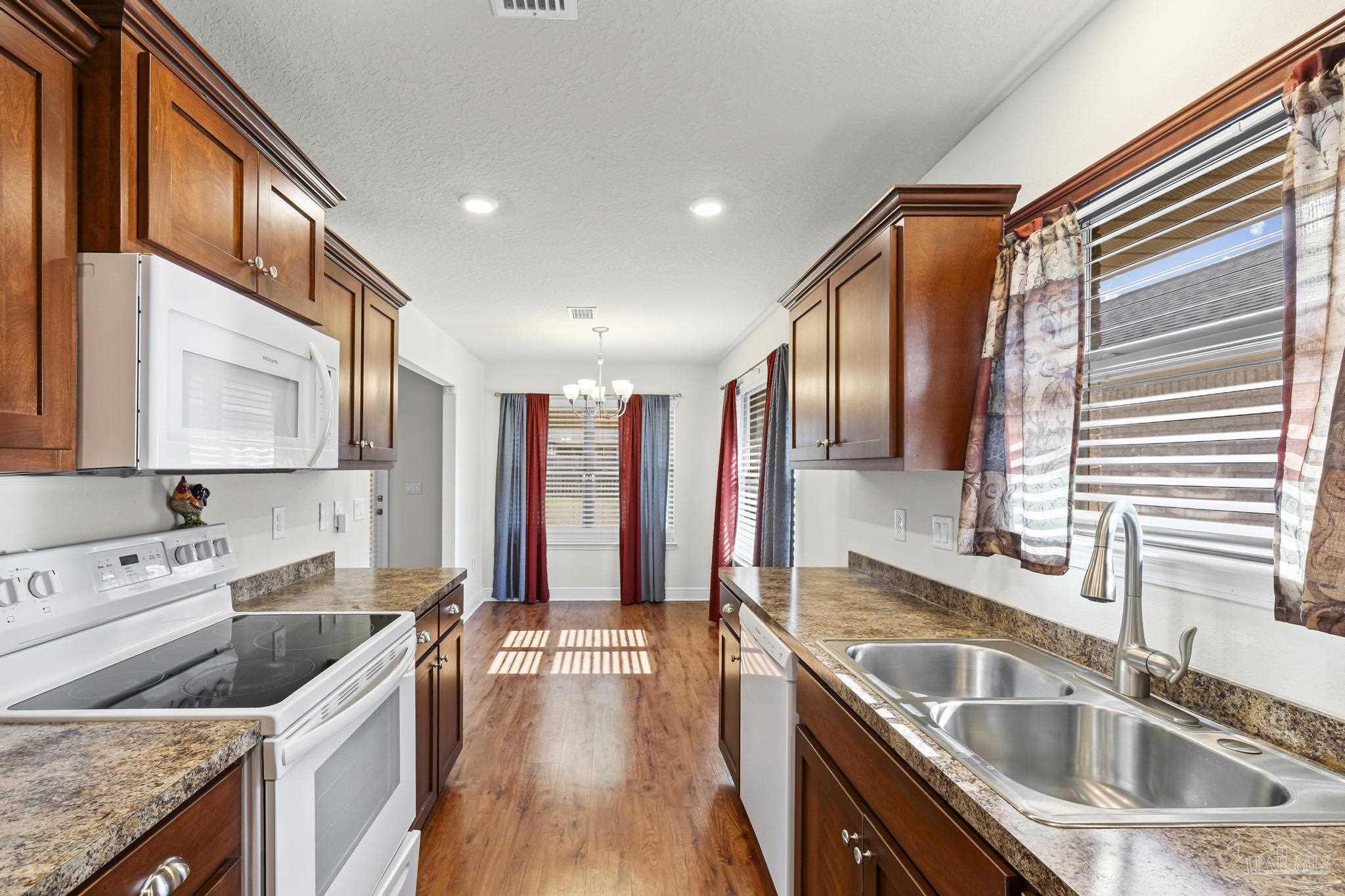 4442 Fiske Street Pace, FL 32571 - Photo 25 of 44 a kitchen with a sink stove top oven and refrigerator