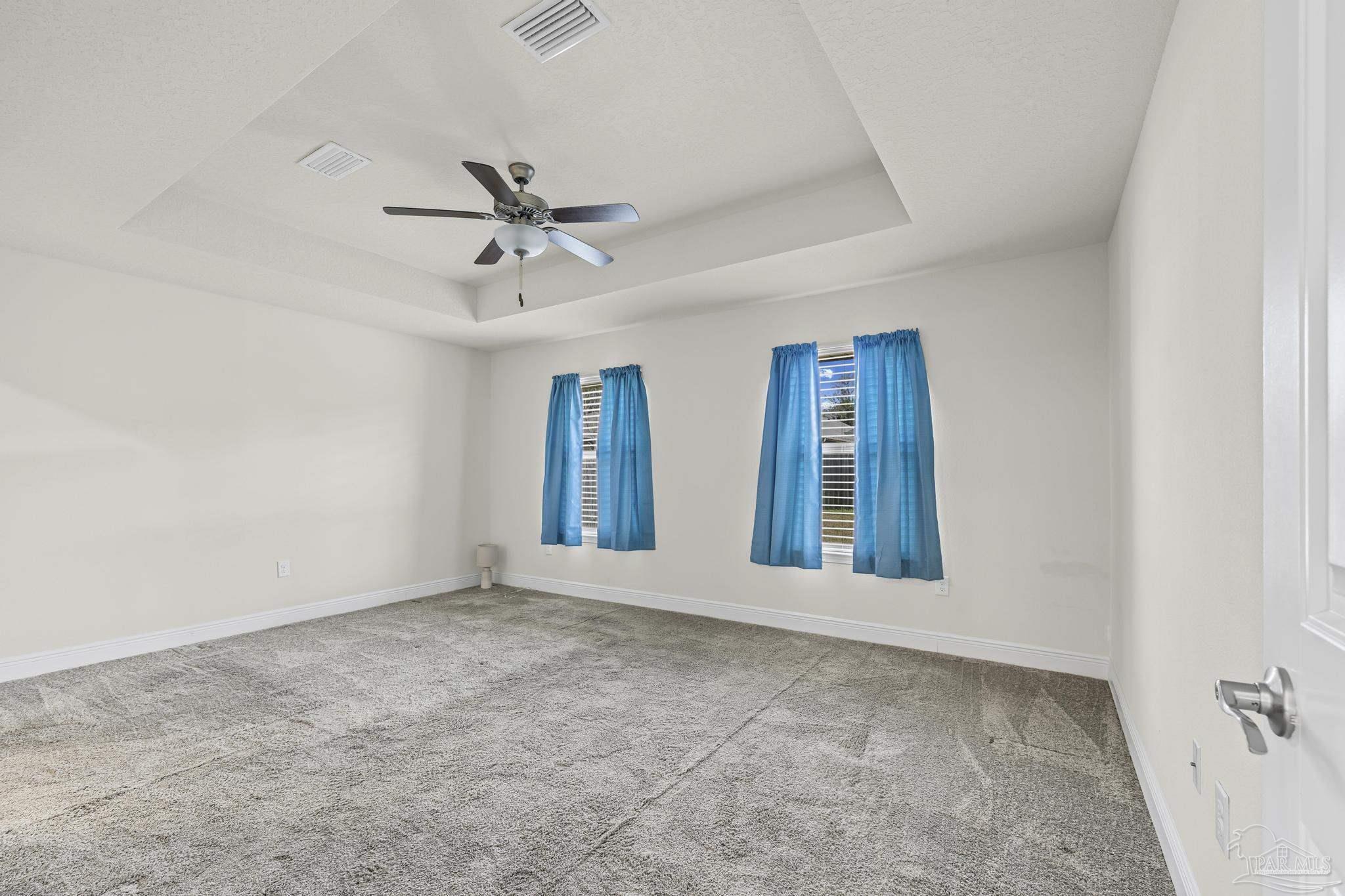 4442 Fiske Street Pace, FL 32571 - Photo 26 of 44 an empty room with chandelier fan and windows