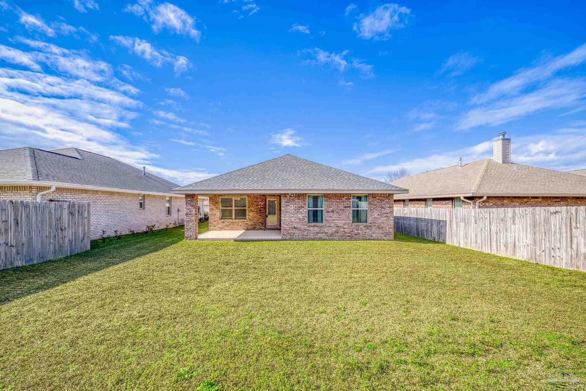 4442 Fiske Street Pace, FL 32571 - Photo 6 of 44 a front view of a house with garden