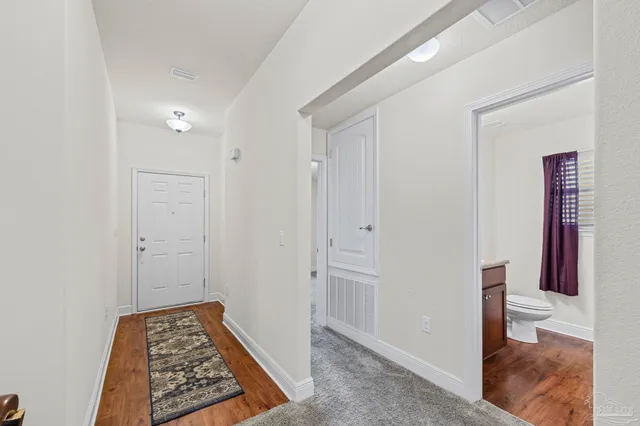 a view of room with wooden floor and bathroom