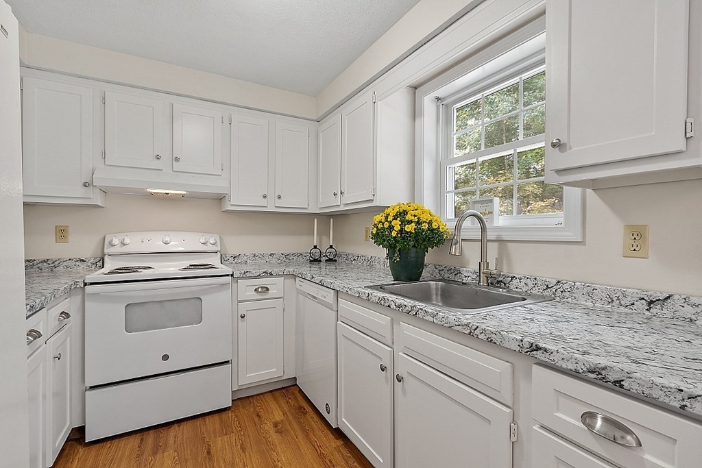 34 Lowell Road, Unit 9 Pepperell, MA 01463 - Photo 2 of 26 a kitchen with granite countertop white cabinets and white appliances