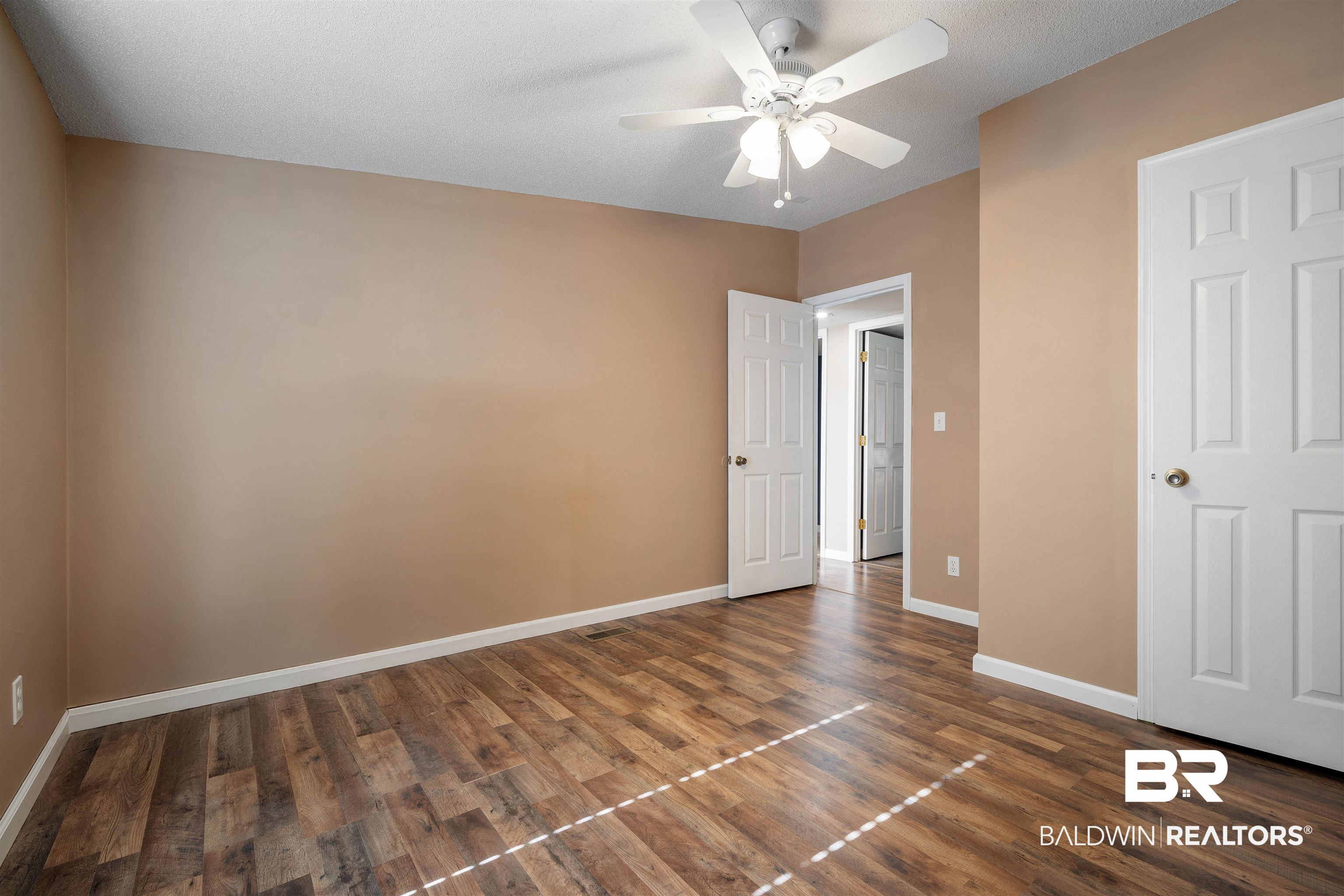 9011 Wilmer Georgetown Road Wilmer, AL 36587 - Photo 20 of 34 Unfurnished bedroom with dark wood finished floors, baseboards, and ceiling fan