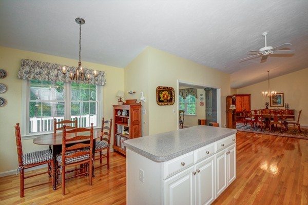 99 Stow Road, Unit 99 Boxborough, MA 01719 - Photo 4 of 27 a kitchen with a table chairs and wooden floor