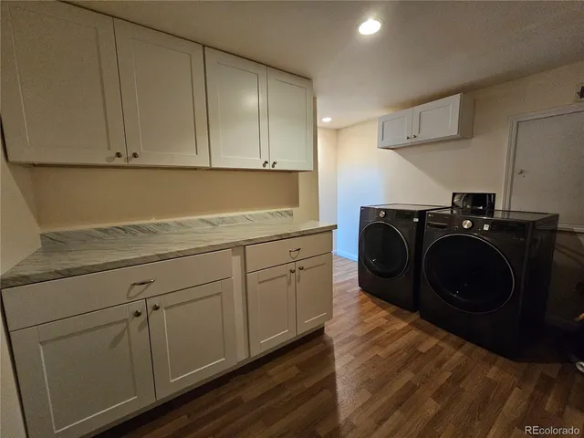 an empty room with wooden floor chandelier fan and windows
