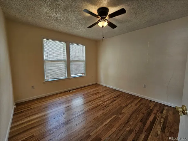 a view of empty room with wooden floor