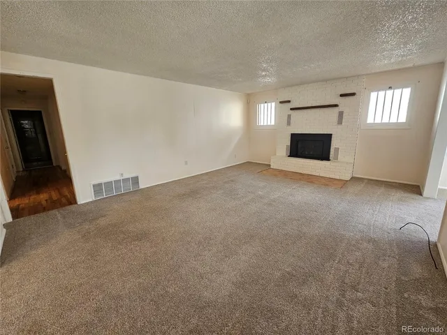 a view of empty room with window and fireplace