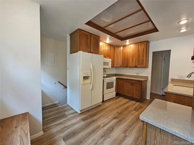 a kitchen with a refrigerator a sink and wooden floor