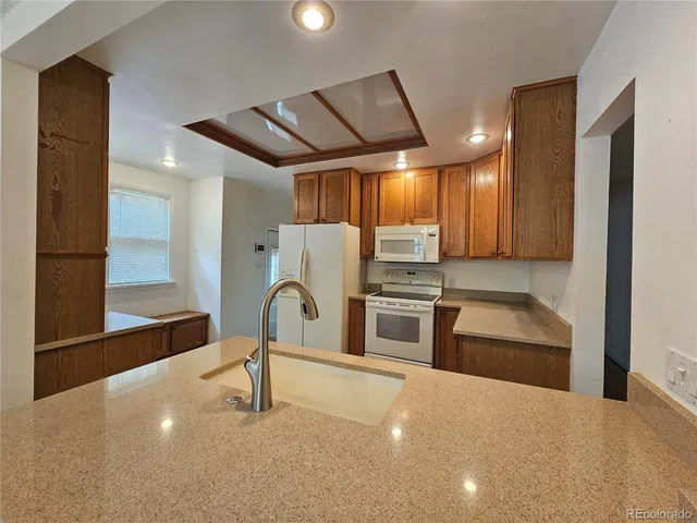 a kitchen with stainless steel appliances a stove a sink and a refrigerator