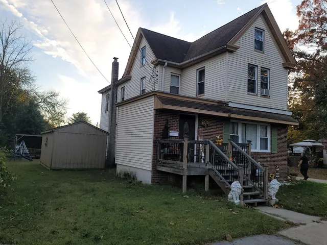 a view of a house with a yard and sitting area