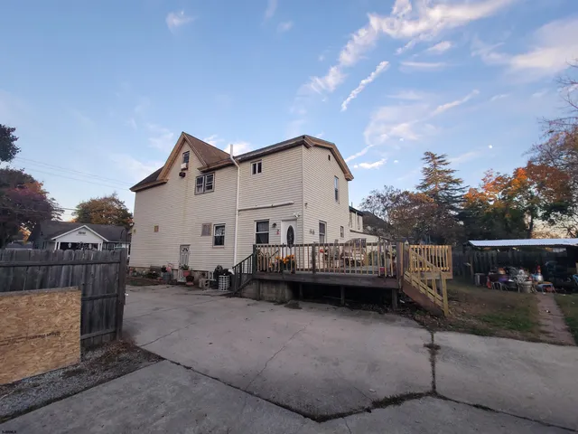 a view of a house with a yard plants and large tree