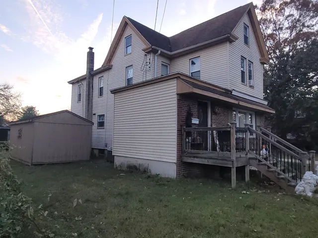 a view of a house with a yard and furniture