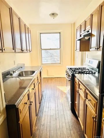 a kitchen with granite countertop a sink stove and cabinets