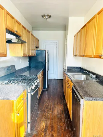 a kitchen with granite countertop a sink a counter top space and stainless steel appliances