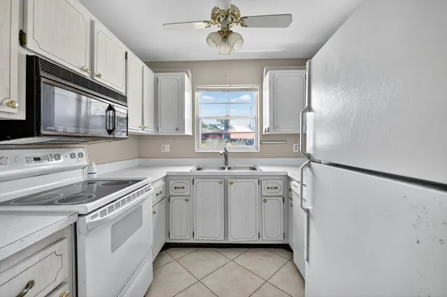 a kitchen with white cabinets and white appliances