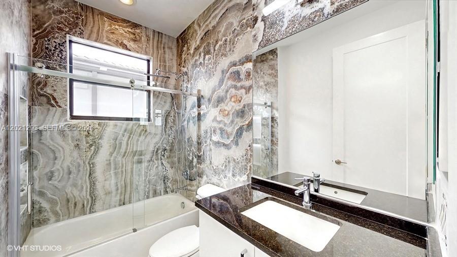 8350 Royal County Down Road Boca Raton, FL 33434 - Photo 30 of 52 a bathroom with a granite countertop sink a toilet and bathtub