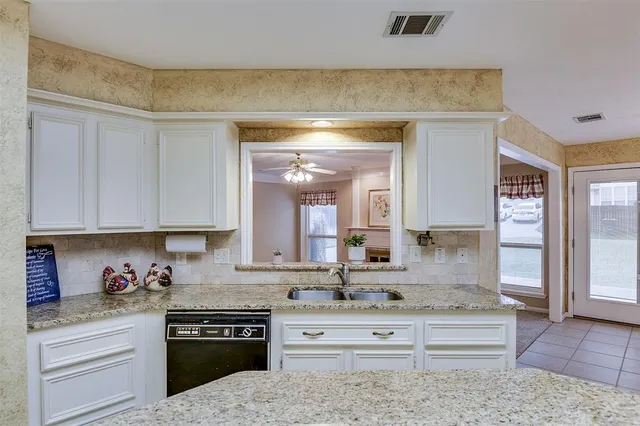 a kitchen with white cabinets and appliances
