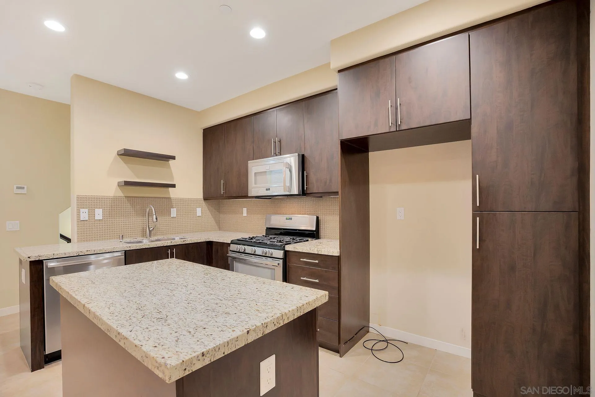 2236 Indus Way San Marcos, CA 92078 - Photo 10 of 30 a kitchen with a sink a refrigerator and a stove top oven