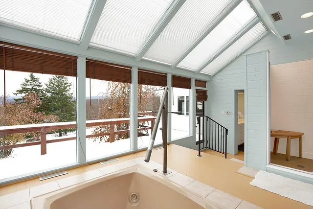 an empty room with windows and fan