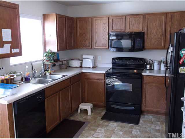 1124 Early Rise Street Raleigh, NC 27610 - Photo 3 of 5 a kitchen with a sink and a stove top oven with wooden floor