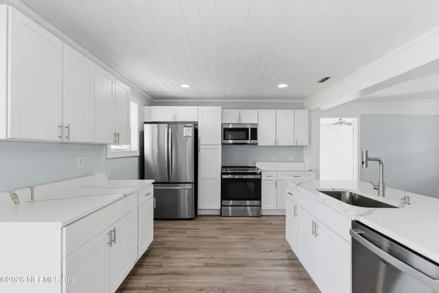 a kitchen with stainless steel appliances a refrigerator sink and cabinets