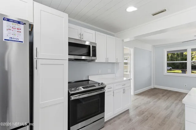 a kitchen with stainless steel appliances a stove a microwave and a refrigerator