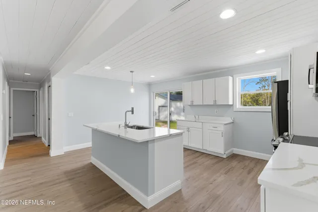 a kitchen with a sink cabinets and wooden floor