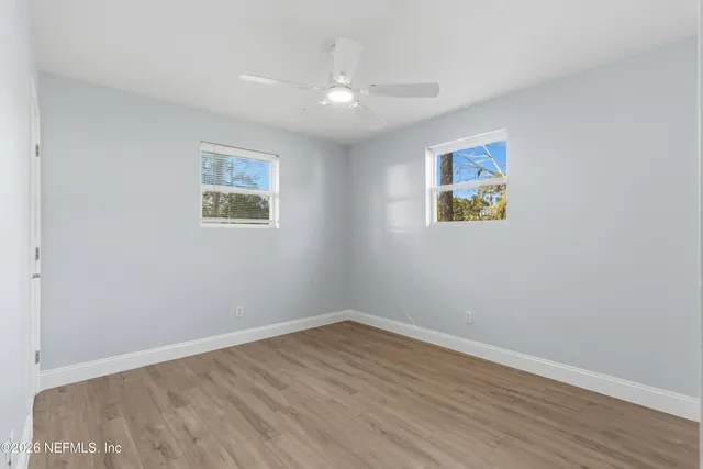 a view of an empty room with wooden floor