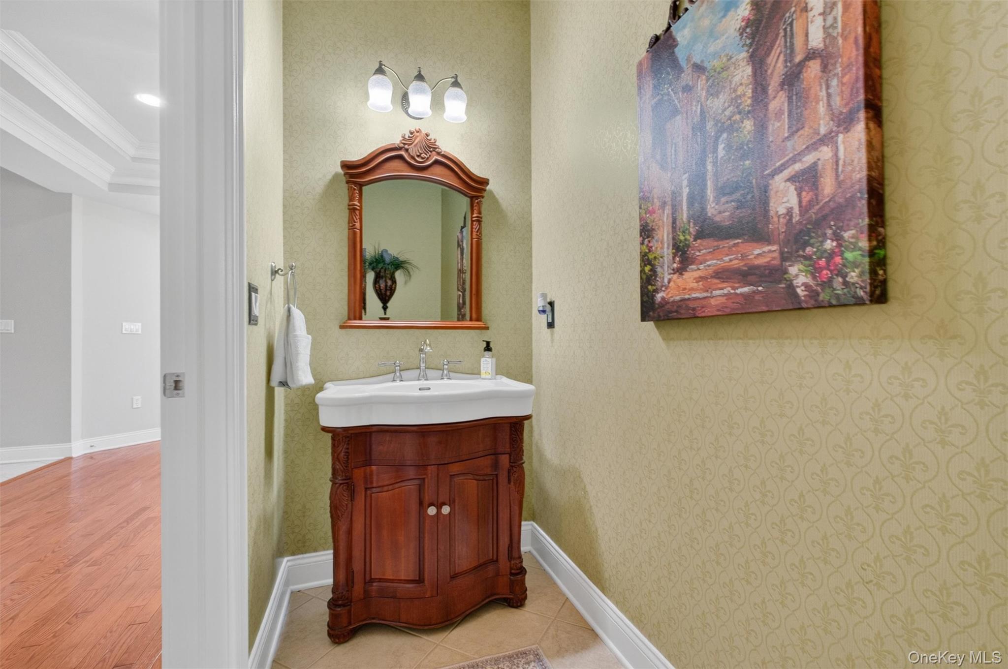 196 Country Club Road Hopewell Junction, NY 12533 - Photo 14 of 50 Conveniently located off the extra-wide hallway between the living room and garage, this oversized lavatory is both beautifully appointed and thoughtfully designed. Elegant wallpaper, Kohler fixtures, and a stylish vanity topped with St. Cecilia granite create a refined and welcoming space for guests and everyday use. Exceptionally spacious for a half bath, the room, together with the generous width of the adjoining hallway, also offers outstanding future flexibility. The layout readily lends itself to the potential addition of a full bath, creating the ideal opportunity to convert the adjacent office into a desirable first-floor in-law or guest suite if ever desired.