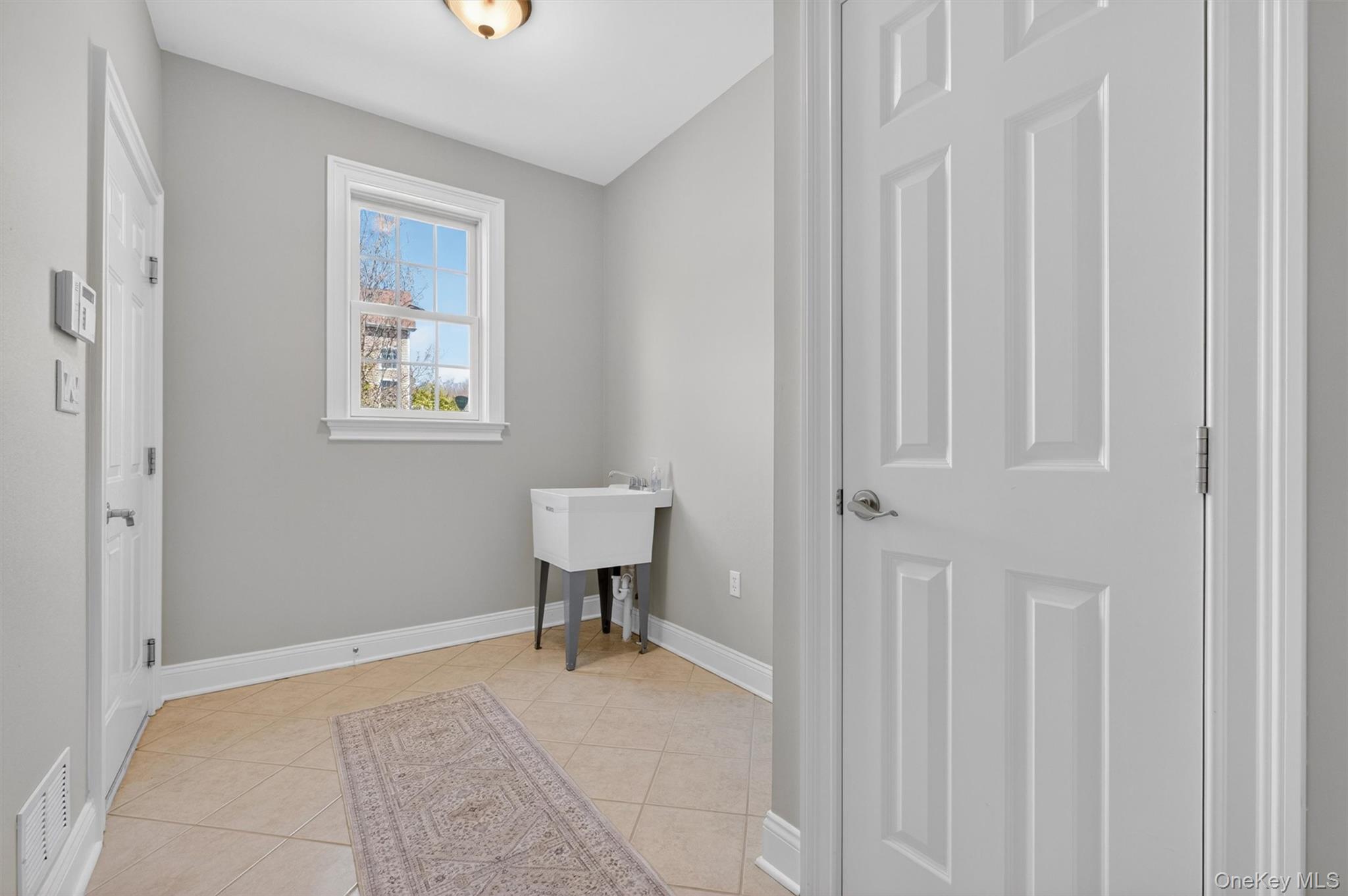 196 Country Club Road Hopewell Junction, NY 12533 - Photo 50 of 50 An incredible mudroom area awaits your vision. Wide, open, and filled with possibility, this expansive blank canvas offers the opportunity to create the mudroom of your dreams—perhaps with walls of custom maple cabinetry, an oversized built-in bench with cubbies below, wall-mounted pegs for coats and backpacks, and abundant storage for shoes, sports gear, and everyday essentials. The possibilities are truly endless: add a convenient side entrance with a charming, covered portico for direct access from the driveway, design an elegant family drop zone, or incorporate additional pantry and storage space while maintaining a clean, polished look. Thoughtfully possible with location of the laundry room on the second floor, this enhanced floor plan provides a rare and generously sized area that maximizes both organization and flow. A covered, maintenance-free Trex portico could further elevate the space, adding year-round shelter, curb appeal, and practicality. Whether your style is classic, modern, or somewhere in