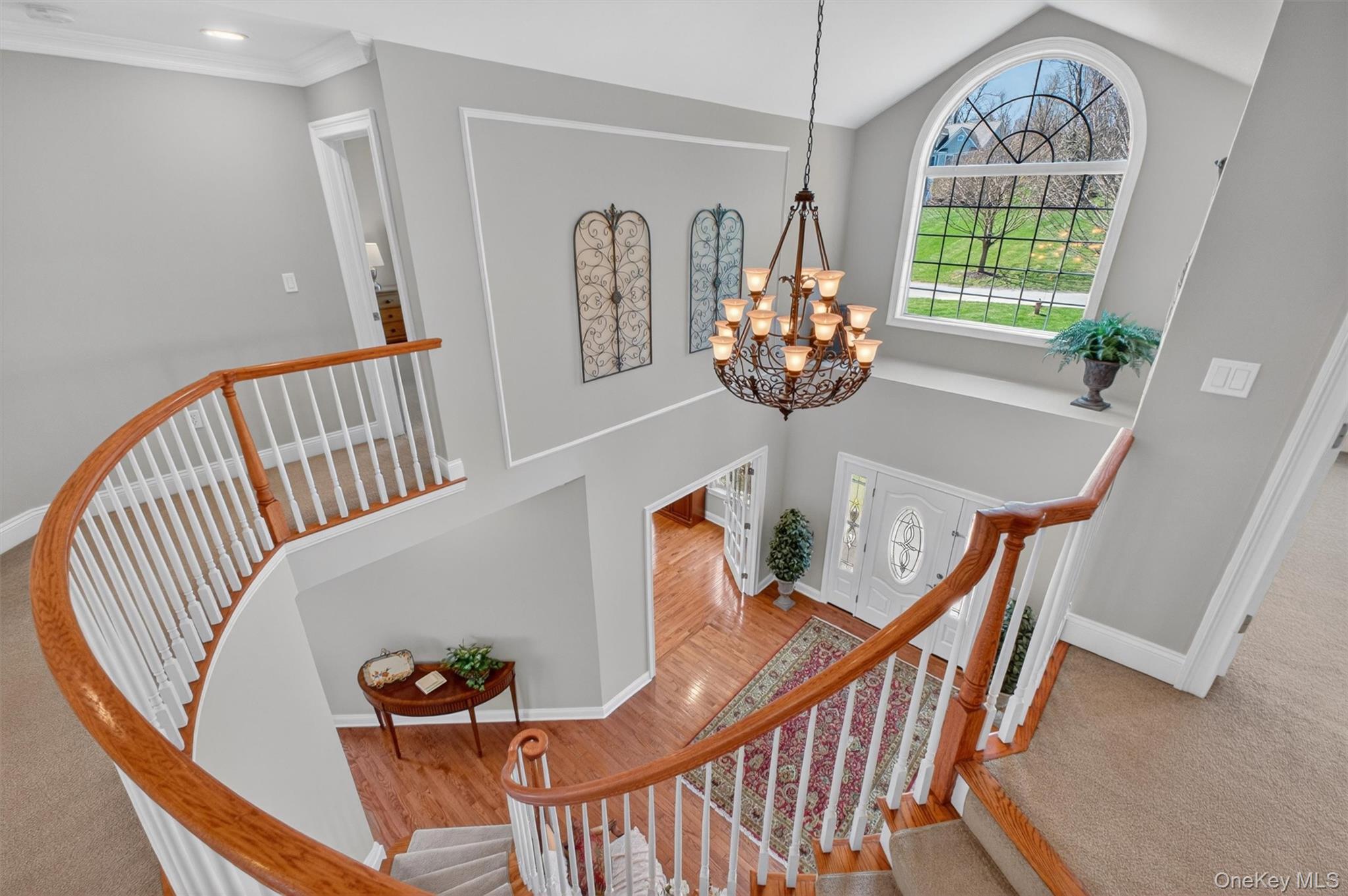 196 Country Club Road Hopewell Junction, NY 12533 - Photo 16 of 50 Designed in the style of a grand reception hall foyer, the impressive upper-level gallery overlooks the dramatic two-story foyer below, creating a breathtaking architectural centerpiece. Accessed by either of the home’s two elegant staircases, this expansive loft-like catwalk serves as the central hub of the second floor. From this striking vantage point, the gallery seamlessly connects the private primary suite and luxurious bath to three additional bedrooms, two full baths, and a separate laundry room. Thoughtfully designed to enhance the home’s open flow, this sophisticated space blends elegance with everyday functionality while showcasing the home’s remarkable scale, light, and architectural presence.