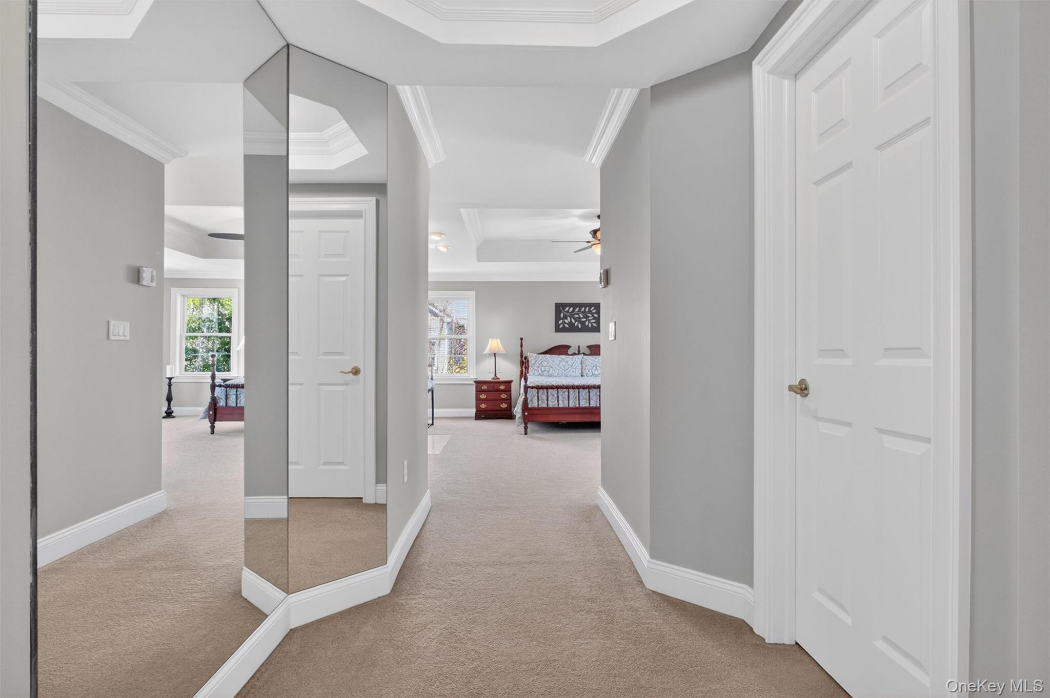 196 Country Club Road Hopewell Junction, NY 12533 - Photo 18 of 50 Experience elevated living in this extraordinary primary suite, a luxurious retreat that spans the entire rear of the home and offers an exceptional blend of space, comfort, and sophistication. Enter through impressive double doors into a beautifully designed suite centered around an oversized 10' x 13' sitting area, where soaring tray ceilings, soft recessed lighting, and expansive windows create a bright yet tranquil ambiance. Thoughtfully appointed with custom cabinetry topped with Giallo granite and a GE Monogram beverage refrigerator, this elegant lounge-like space is perfect for morning coffee, quiet evenings, or a private media retreat.