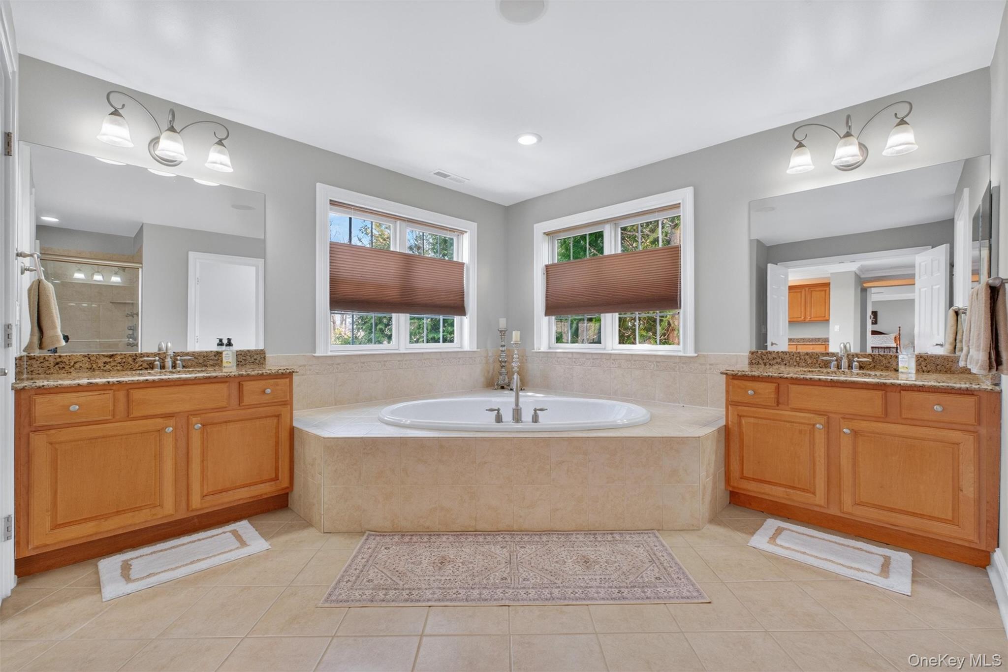 196 Country Club Road Hopewell Junction, NY 12533 - Photo 20 of 50 At the opposite end of the suite, the ultra-luxurious primary bath offers a private spa-like retreat of exceptional scale and elegance. Centered around an elegant Kohler Jacuzzi soaking tub, the room is bathed in natural light from two sets of double windows that frame breathtaking mountain views, creating a serene and relaxing setting. A massive custom walk-in shower with a sleek glass enclosure adds to the spa-inspired feel, while separate his-and-her vanities with recessed medicine cabinets provide both beauty and function. A private water closet completes this extraordinary ensuite, delivering the perfect balance of luxury, comfort, and privacy.