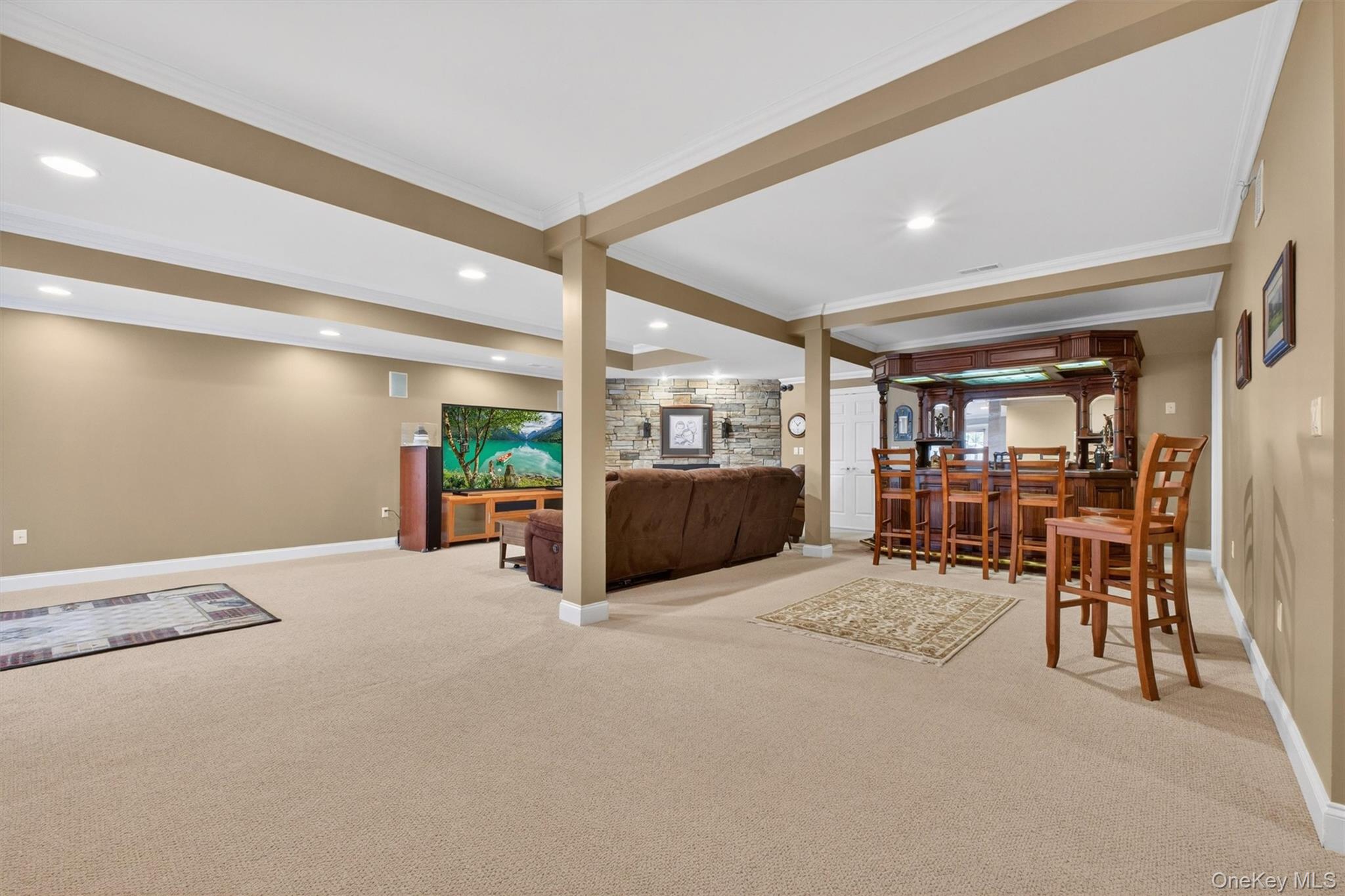 196 Country Club Road Hopewell Junction, NY 12533 - Photo 30 of 50 The recently finished basement is a spectacular retreat designed for both entertaining and everyday enjoyment. Anchored by a stately stone custom gas fireplace—the home’s third—this expansive space offers warmth and character throughout. From the billiards area, you’ll enjoy a full view of the open-concept layout, which flows seamlessly into a cozy media and living zone, perfect for movie nights or watching the big game. A beautifully crafted wet bar featuring rich teak finishes and stained-glass accents adds a touch of artistry, while the impressive 800-bottle temperature- and humidity-controlled wine cellar is a true standout for collectors. Complete with a fourth full bath and pre-wired for a 7.2 surround sound system, this incredible lower level is a dream space for both kids and adults, blending luxury, comfort, and entertainment in one exceptional setting.