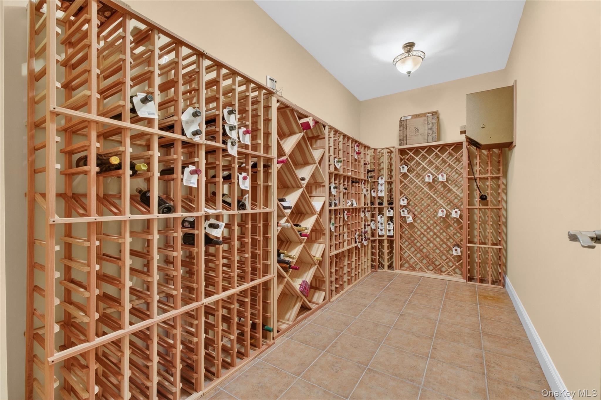 196 Country Club Road Hopewell Junction, NY 12533 - Photo 31 of 50 A true highlight for wine enthusiasts, the impressive 800-bottle temperature- and humidity-controlled wine cellar offers the perfect environment for preserving and showcasing a prized collection. Thoughtfully designed with both function and ambiance in mind, this exceptional space features a rich terracotta tile floor that adds warmth, character, and old-world charm. Ideal for both seasoned collectors and casual connoisseurs, the cellar provides optimal storage conditions while creating a sophisticated setting to curate, display, and enjoy your finest selections. Whether expanding your collection or entertaining guests, this beautifully appointed wine cellar is a rare and luxurious addition to the home.