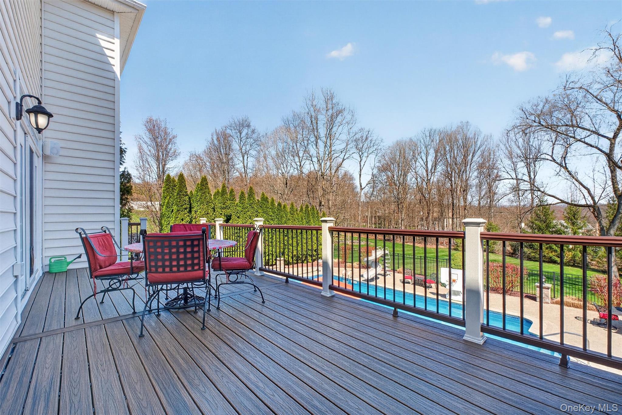 196 Country Club Road Hopewell Junction, NY 12533 - Photo 36 of 50 Perched atop in the prestigious Legends neighborhood, this newly completed expansive Trex deck offers breathtaking, private views that create your own personal retreat. Overlooking sweeping natural landscapes, this extraordinary outdoor space delivers a true sense of escape—your very own Nature’s Paradise. Whether hosting gatherings or unwinding at the end of the day, you’ll feel as though you’ve arrived at a private resort while enjoying all the comforts of this beautifully designed contemporary colonial in the heart of the Hudson Valley. The panoramic vistas provide a stunning backdrop for both lively entertaining and quiet moments of relaxation. Designed for effortless outdoor living, the deck features maintenance-free Trex decking, durable vinyl railings, and a custom staircase leading to the lower patio, seamlessly blending elegance, durability, and function in a truly spectacular setting.