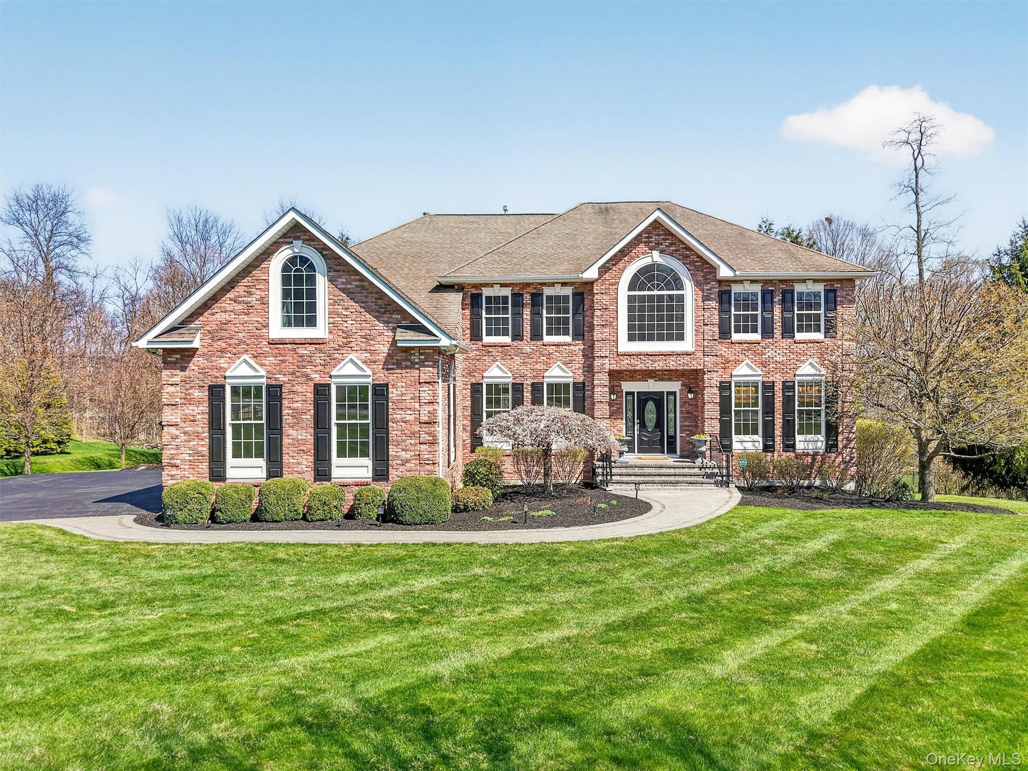 196 Country Club Road Hopewell Junction, NY 12533 - Photo 4 of 50 A rare offering of Lennar’s most luxurious and highly upgraded Sinclair model, this distinguished residence reflects the craftsmanship of a premier national builder and showcases timeless architectural design. The exterior makes an unforgettable first impression with its elegant brick façade, refined stone walkway, and freshly painted shutters, all anchored by an impressive, oversized stone entry. A striking glass door and side lights creates a grand sense of arrival, while the professionally designed and meticulously maintained manicured grounds add warmth, character, and an undeniable level of sophistication to the home’s exceptional curb appeal.