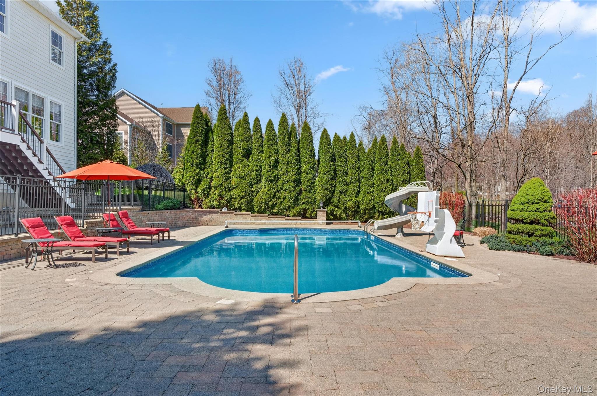 196 Country Club Road Hopewell Junction, NY 12533 - Photo 41 of 50 This spectacular pool area is the epitome of resort-style living, where every detail has been thoughtfully curated to create a truly elevated outdoor experience. The impressive 22' x 48' in-ground pool is equipped with a heater, new pump, new salt cell, and new filter, along with a full automation system for effortless control. Designed for both enjoyment and efficiency, it also features a slide, solar cover, and Loop-Loc safety cover, offering the perfect balance of fun, functionality, and peace of mind. Surrounded by an expansive patio ideal for lounging and entertaining, this exceptional setting reflects a no-expense-spared approach—crafted to deliver a legendary lifestyle right in your own backyard.