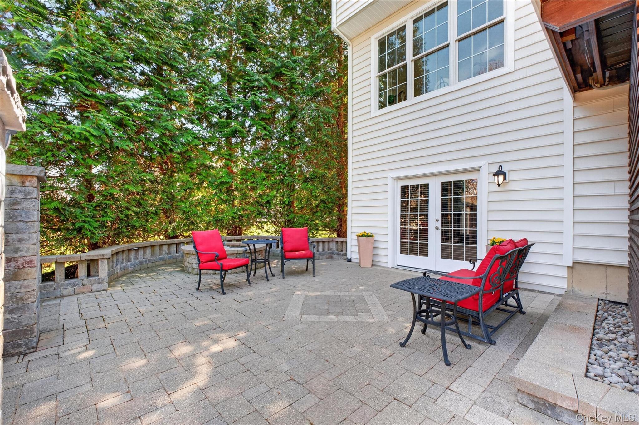 196 Country Club Road Hopewell Junction, NY 12533 - Photo 42 of 50 The fire pit patio is a warm and inviting focal point, thoughtfully designed for gathering, relaxing, and enjoying the outdoors year-round. Anchored by a custom fire pit, this cozy yet spacious area creates the perfect setting for evenings under the stars. Ideally positioned, it offers direct access to the walk-out basement, providing a seamless connection between indoor and outdoor living—perfect for entertaining or accommodating multi-generational living with ease. Whether hosting guests or enjoying quiet moments by the fire, this beautifully integrated space enhances both the functionality and lifestyle of the home.