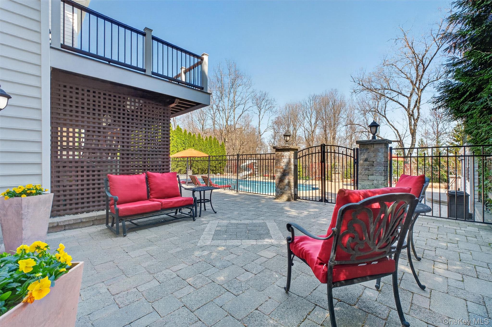 196 Country Club Road Hopewell Junction, NY 12533 - Photo 43 of 50 The fire pit patio area serves as a central gathering space within this thoughtfully designed outdoor retreat, offering seamless access to the upper deck, pool area, and walk-out lower level—perfect for multi-generational living and effortless entertaining. Beautifully integrated into the expansive Unilock patio, this inviting space is anchored by a custom fire pit, creating the ideal setting for cozy evenings, conversation, and year-round enjoyment. Its strategic location allows for easy flow between all levels of the home, whether hosting guests, accommodating extended family, or simply enjoying the versatility of indoor-outdoor living. Designed for both connection and convenience, this exceptional space enhances the functionality and lifestyle appeal of the entire property.